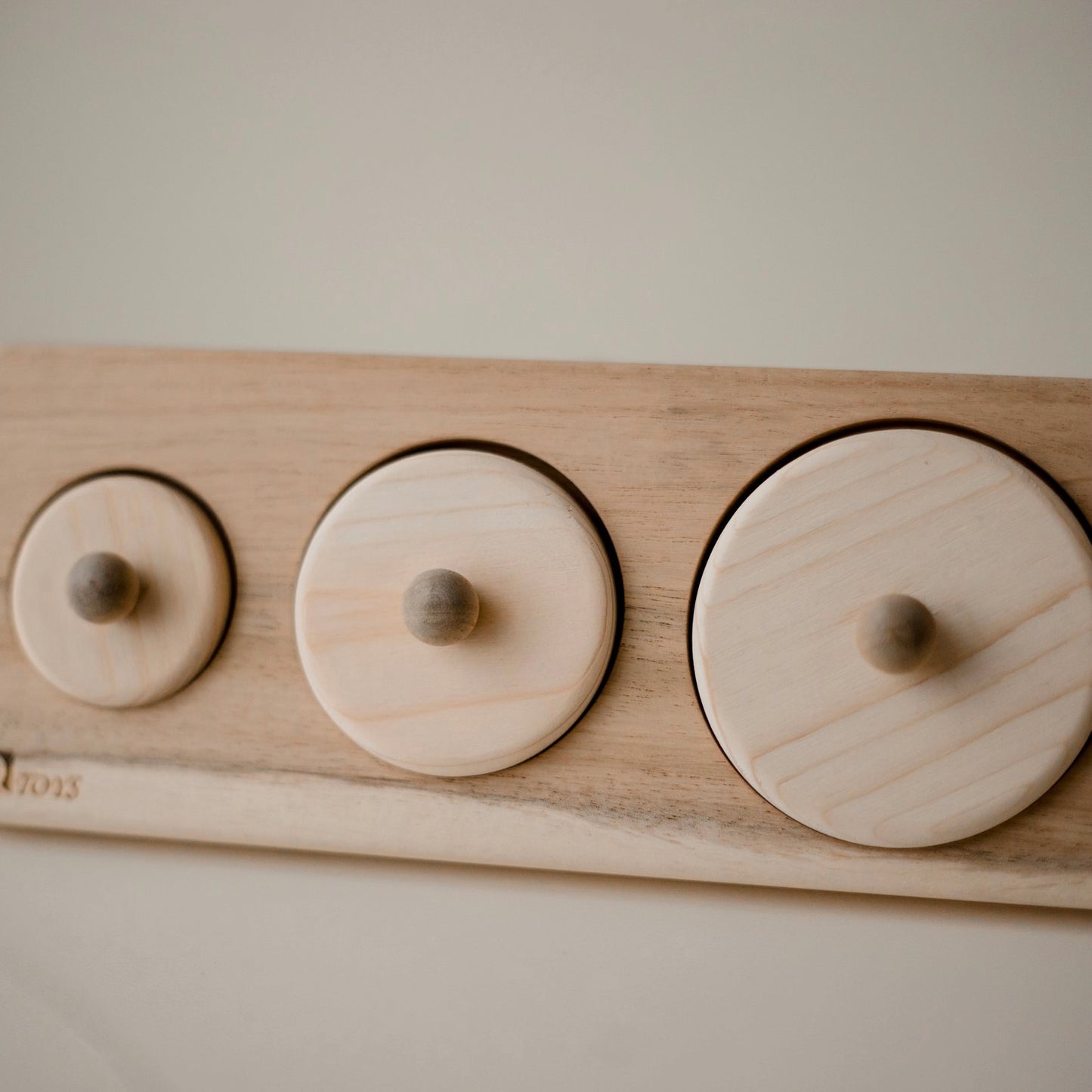 wooden puzzle consisting of 3 ascending circles. each puzzle has a small knob for child to hold. 